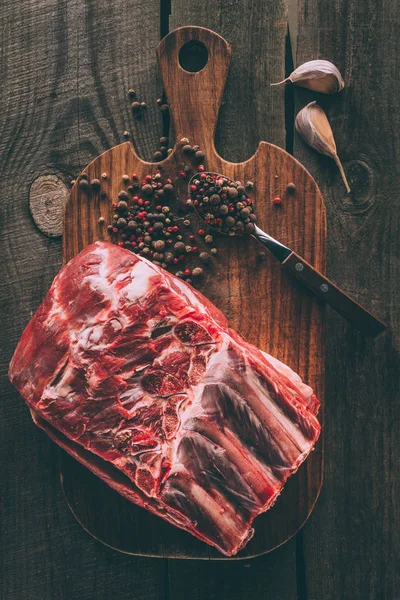 Top view of raw pork ribs with peppercorn on wooden cutting board — Stock Photo