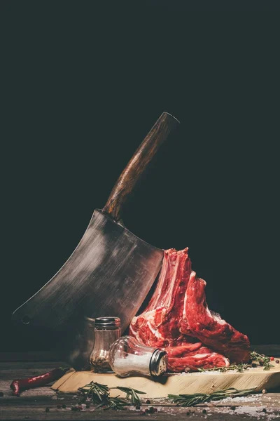 Raw pork ribs on cutting board with spices and butcher cleaver — Stock Photo