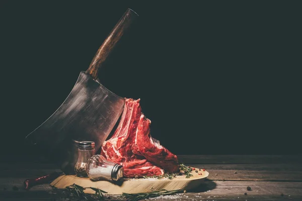 Raw pork ribs with butcher cleaver and spices on wooden board — Stock Photo