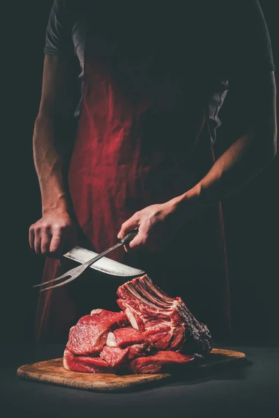 Couteau à aiguiser boucher pour couper la viande crue sur planche à découper en bois — Photo de stock