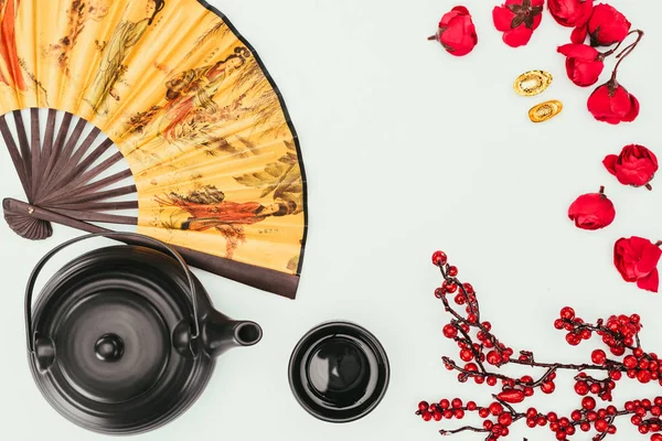 Vista superior de la composición de año nuevo chino con té y ventilador de mano aislado en blanco - foto de stock