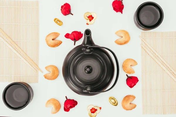 Top view of chinese teapot with flowers and fortune cookies isolated on white — Stock Photo