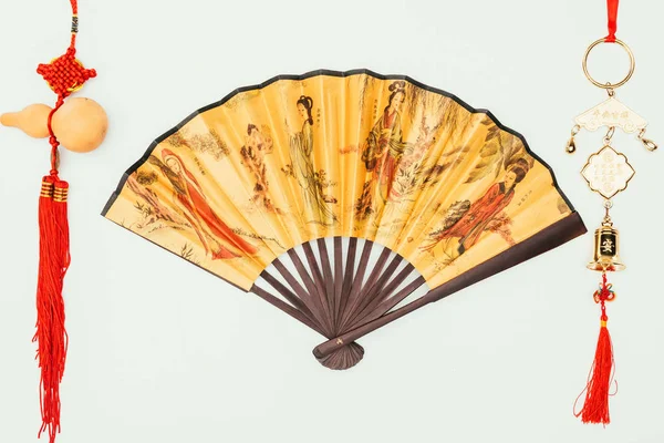 Vista superior del ventilador de mano chino con talismanes aislados en blanco - foto de stock