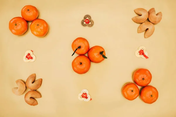 Vue du dessus des pièces chinoises avec mandarines et composition de biscuits de bonne aventure pour la nouvelle année — Photo de stock