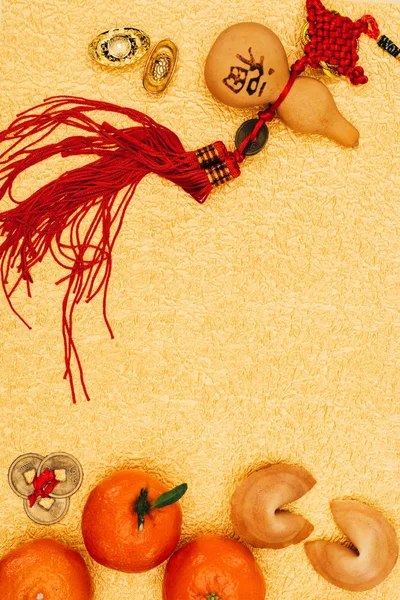 Top view of traditional chinese talisman with tangerines and fortune cookies on golden surface, Chinese New Year concept — Stock Photo