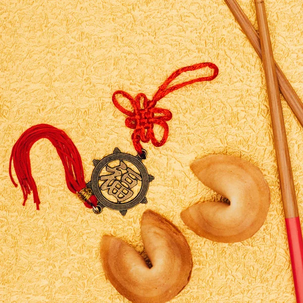 Blick von oben auf chinesischen Talisman und Glückskekse auf goldener Oberfläche, chinesisches Neujahrskonzept — Stockfoto