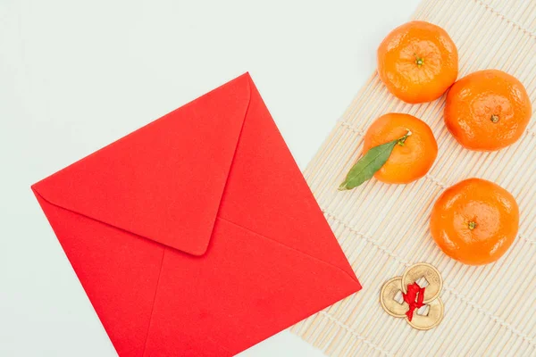 Top view of red envelope with tangerines and chinese coins talisman, Chinese New Year concept — Stock Photo