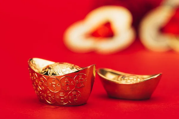 Close-up shot of chinese golden ingots on red surface — Stock Photo