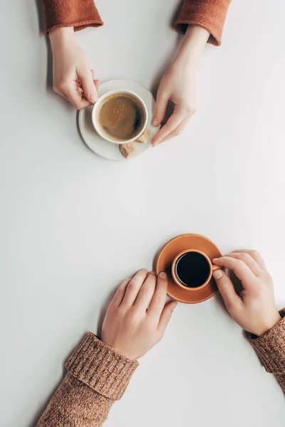 Vue de dessus des mains masculines et féminines avec des tasses de café sur blanc — Photo de stock