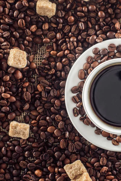 Tazza di caffè, chicchi di caffè tostati e zucchero di canna su sacco — Foto stock