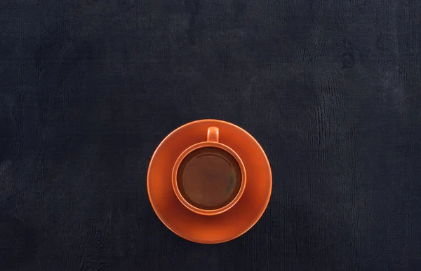 Vue du dessus de tasse de café avec soucoupe sur noir — Photo de stock