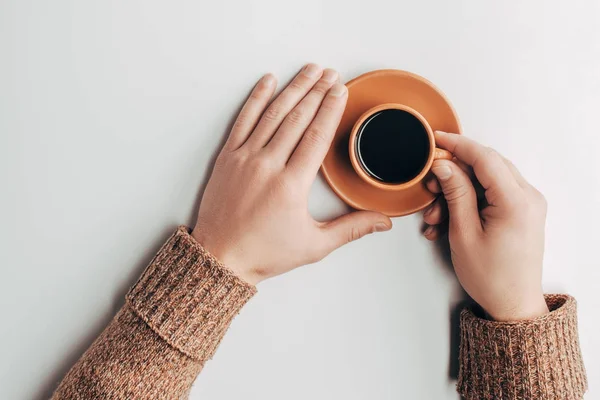 Vue de dessus des mains humaines et tasse de café sur gris — Photo de stock