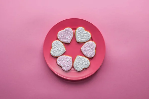 Вид сверху на сладкое застекленное печенье на тарелке изолированы на розовый, День святого Валентина праздничной концепции — стоковое фото