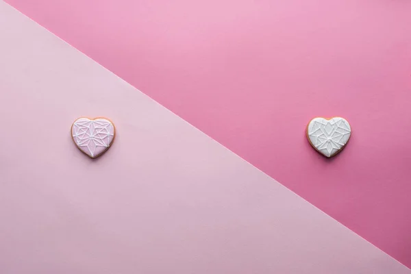 Vue d'en haut des biscuits doux en forme de coeur sur rose, concept St Valentin — Photo de stock