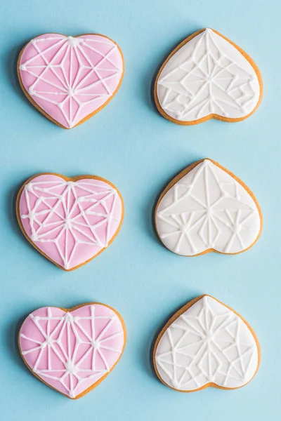 Flat lay with arranged glazed heart shaped cookies isolated on blue, st valentines day holiday concept — Stock Photo