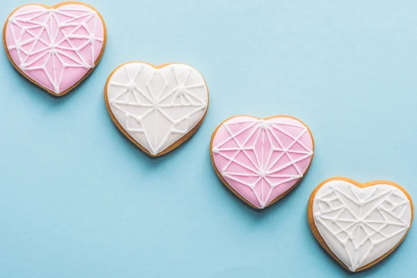 Flat lay with arranged glazed heart shaped cookies isolated on blue, st valentines day holiday concept — Stock Photo