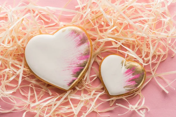 Vista de cerca de las galletas en forma de corazón dulce y paja decorativa en rosa, San Valentín concepto de vacaciones - foto de stock