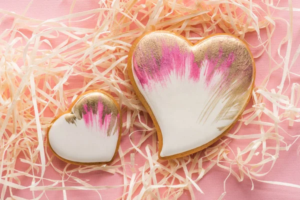 Vue rapprochée de biscuits doux en forme de coeur et de paille décorative sur rose, concept de vacances St Valentin — Photo de stock