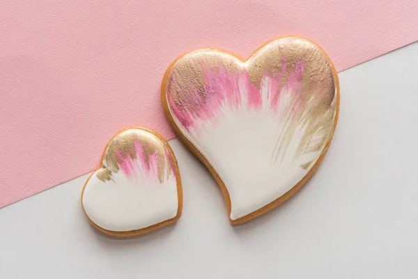 Vista superior de las galletas vidriadas en forma de corazón aisladas en la superficie rosa - foto de stock