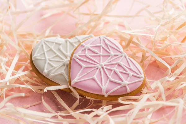 Vue rapprochée de biscuits doux en forme de coeur et de paille décorative sur rose, concept de vacances St Valentin — Photo de stock