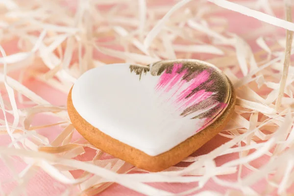 Close up vista de doce coração em forma de biscoito e palha decorativa em rosa, st Valentines conceito de férias — Fotografia de Stock