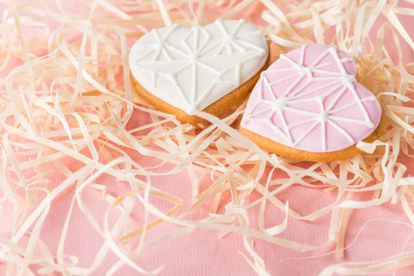 Vista de perto de biscoitos em forma de coração doce e palha decorativa em rosa, st Valentines conceito de férias — Fotografia de Stock