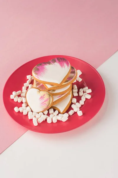 Vista de perto de biscoitos em forma de coração e marshmallow na placa rosa — Fotografia de Stock