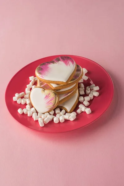 Vista de perto de biscoitos em forma de coração e marshmallow na placa isolada em rosa — Fotografia de Stock