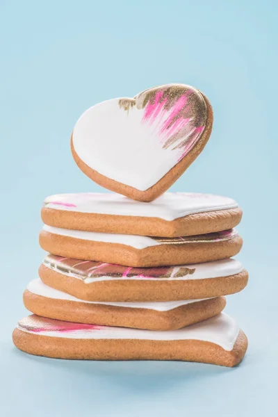 Close up view of pile of glazed heart shaped cookies isolated on blue, st valentines day concept — Stock Photo