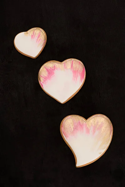 Draufsicht auf arrangierte herzförmige Kekse auf dunkler Oberfläche — Stockfoto