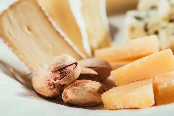 Blick auf Pistazien in ihren Schalen, die auf Teller mit Fruchtscheiben liegen — Stockfoto