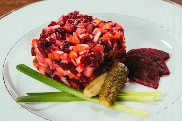 Vue rapprochée de la salade de vinaigre servie avec oignon vert et concombre mariné sur assiette blanche — Photo de stock