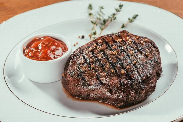 Steak frit posé sur une assiette avec sauce — Photo de stock