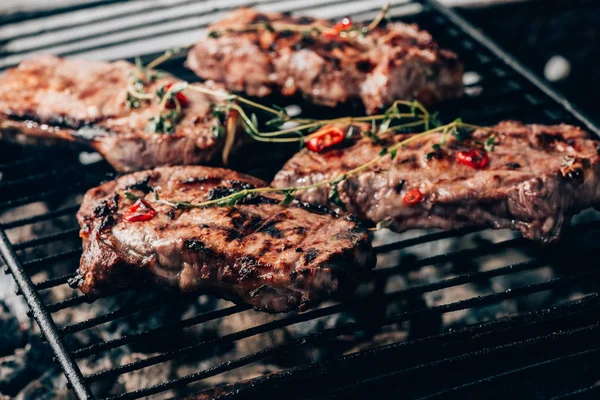 Vista de perto da carne suculenta gourmet com especiarias cozinhando na grelha — Fotografia de Stock