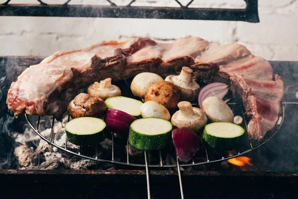 Close-up view of delicious meat with vegetables preparing on grill — Stock Photo