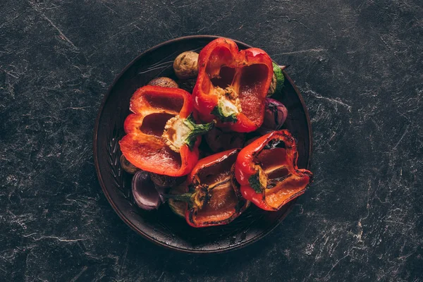 Vue du dessus de délicieux légumes rôtis dans une assiette sur noir — Photo de stock