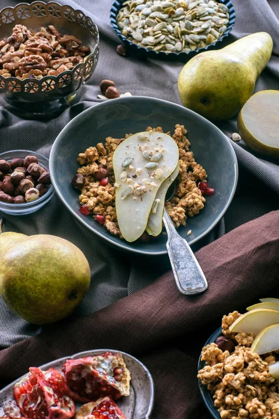 Overhead view of bowl with granola and pear on tabletop — Stock Photo