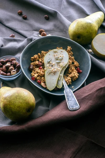 Vista aérea da tigela com granola e pêra na mesa — Fotografia de Stock