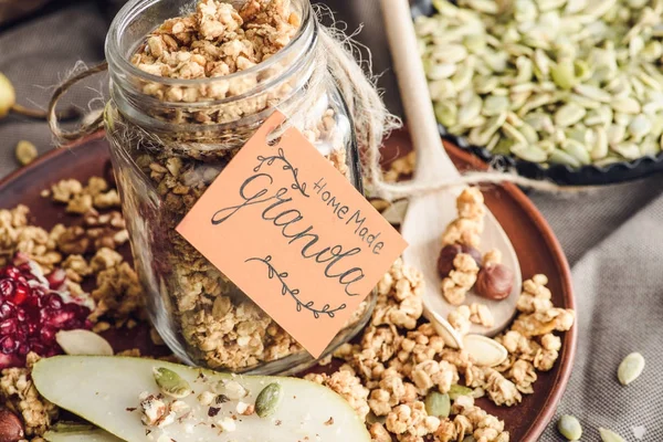 Homemade tasty granola in glass jar with tag — Stock Photo