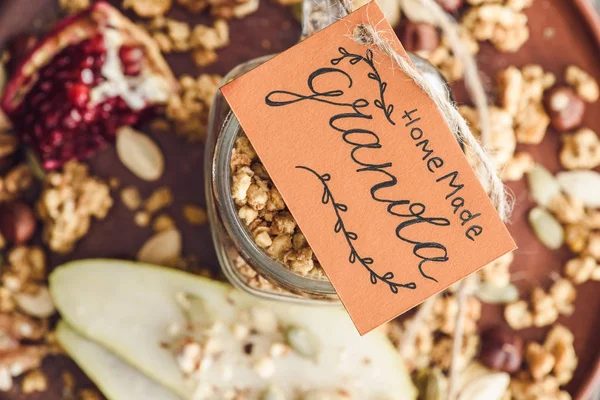 Top view of homemade granola in glass jar with tag — Stock Photo