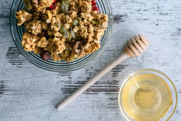 Vue de dessus de granola et bol en verre avec du miel sur la table — Photo de stock