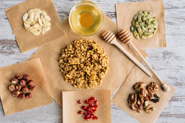 Vue de dessus des ingrédients de granola faits maison sur les morceaux de parchemin de cuisson — Photo de stock