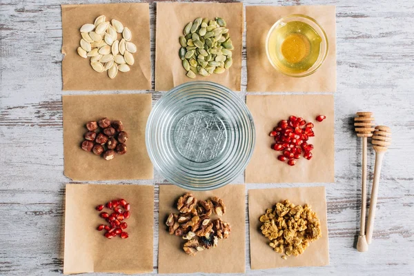 Vista dall'alto degli ingredienti della granola sui pezzi di pergamena da forno in tavola — Foto stock