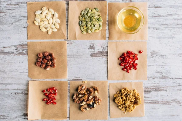 Vue de dessus des ingrédients de granola sur les morceaux de parchemin de cuisson — Photo de stock