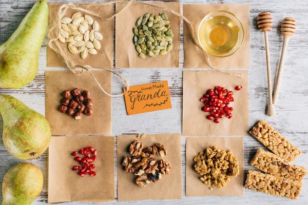 Vista dall'alto degli ingredienti della granola e etichetta sui pezzi di pergamena di cottura — Foto stock
