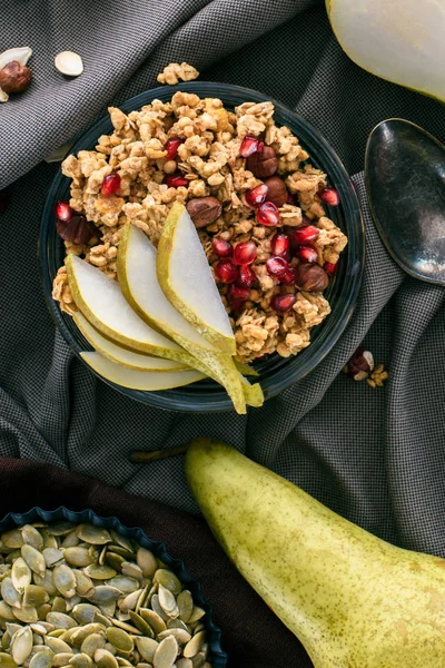 Vue de dessus du granola croquant avec des poires et des graines de grenade sur la table — Photo de stock