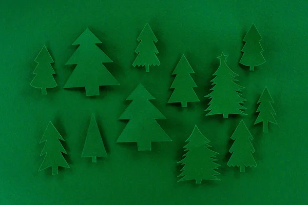 Vue du dessus des arbres de Noël en papier décoratif vert sur fond vert — Photo de stock