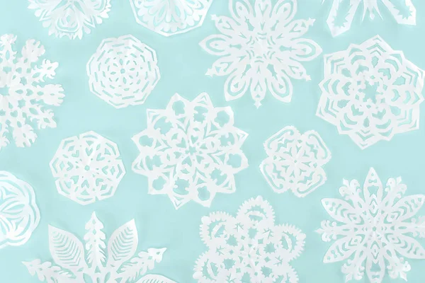 Fond de Noël avec des flocons de neige décoratifs en papier, isolé sur bleu clair — Photo de stock