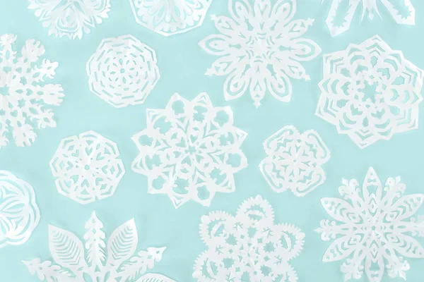 Fondo de Navidad con copos de nieve de papel decorativo, aislado en azul claro - foto de stock