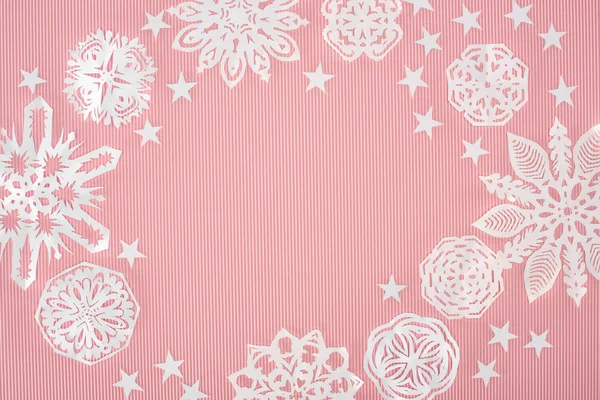 Christmas frame with paper snowflakes and stars on pink background — Stock Photo